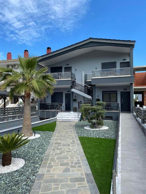 a house with a palm tree in front of it at ONAR PALACE in Nea Peramos