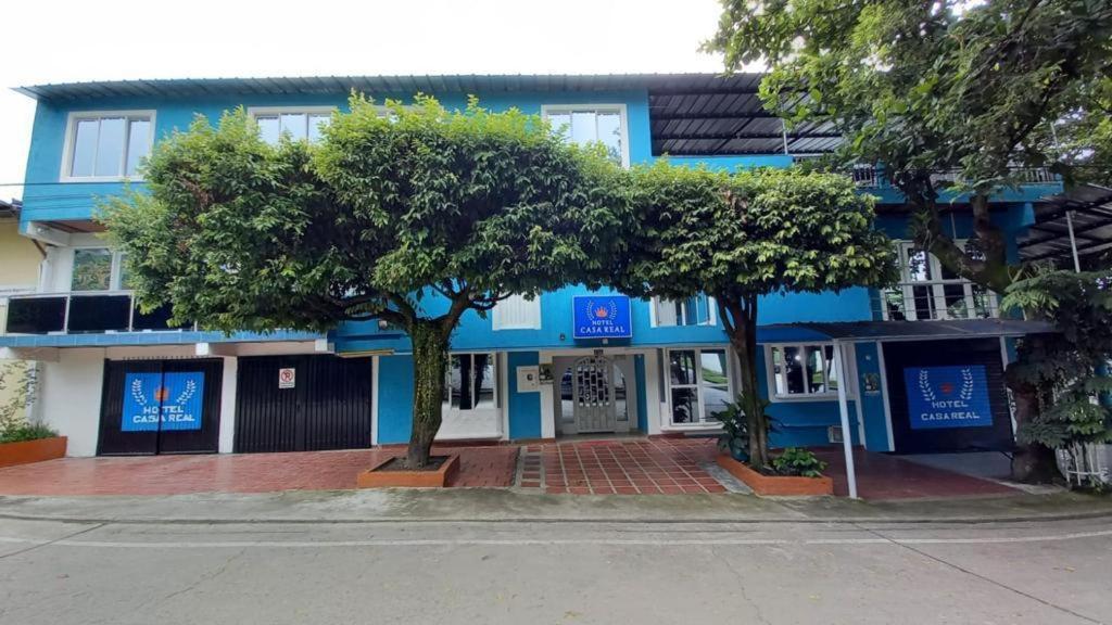 a blue building with trees in front of it at HOTEL Casa Real RIVERA HUILA in Rivera