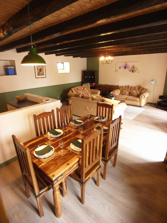 une salle à manger avec une table et des chaises en bois dans l'établissement Gîte Cerise - Les Gîtes de la Lohuas, à Les Champs-Géraux