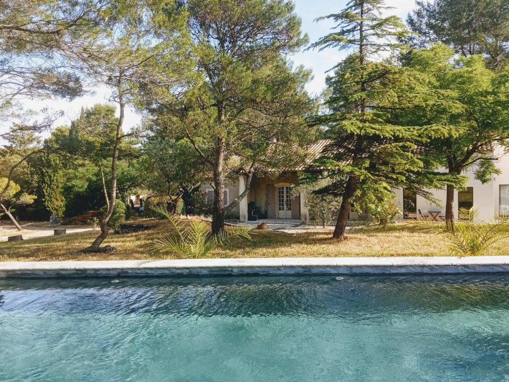 une maison avec une piscine devant une maison dans l'établissement Maison de Charme avec piscine dans le Parc Naturel des Alpilles, à Saint-Rémy-de-Provence