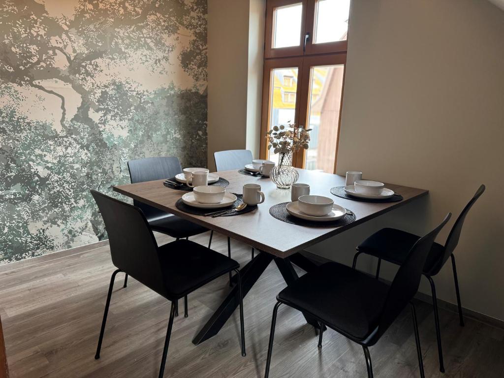 a dining room table with black chairs and a table and a table and chairsktop at Stilapartment City 3 in Wernigerode