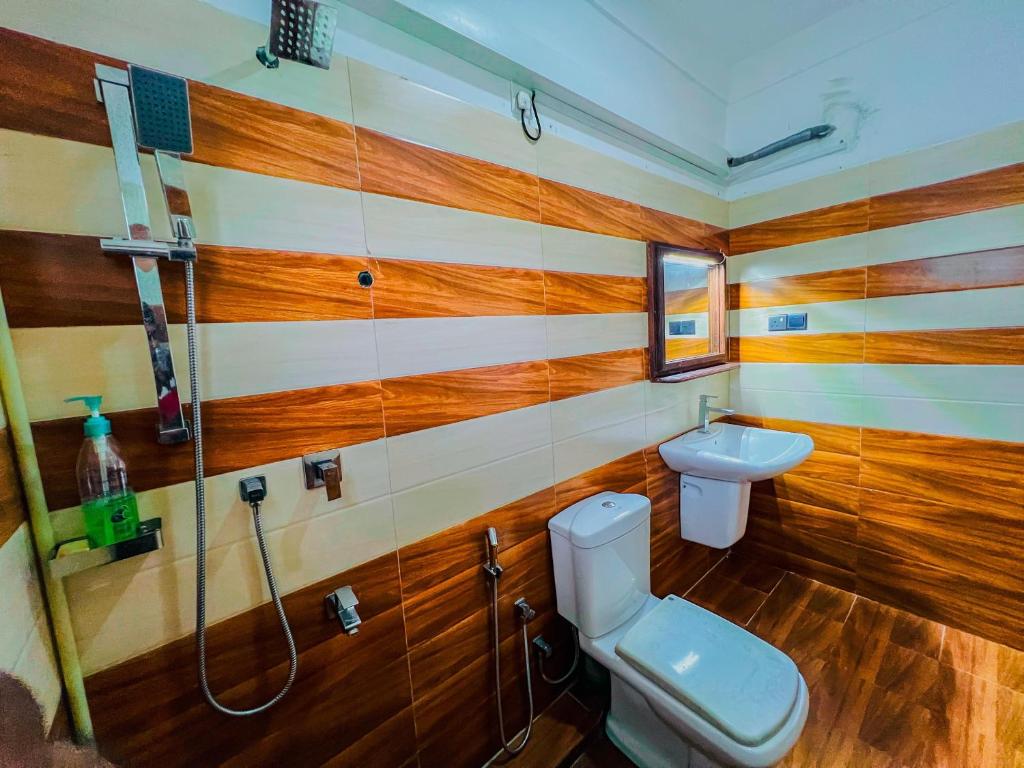 a bathroom with a toilet and a shower at Ocean Wave Hikakduwa in Hikkaduwa