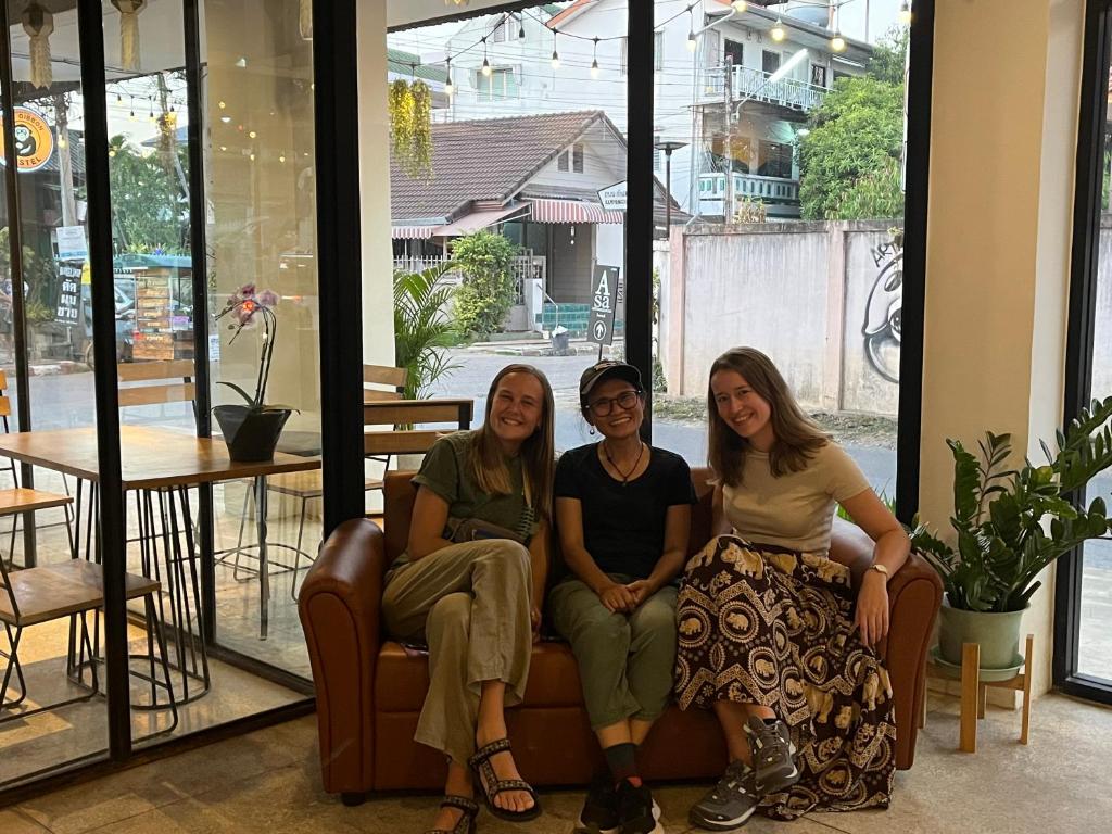 a group of three women sitting on a couch at Lazy Gibbon 2 Chiang Mai - Haiya in Chiang Mai