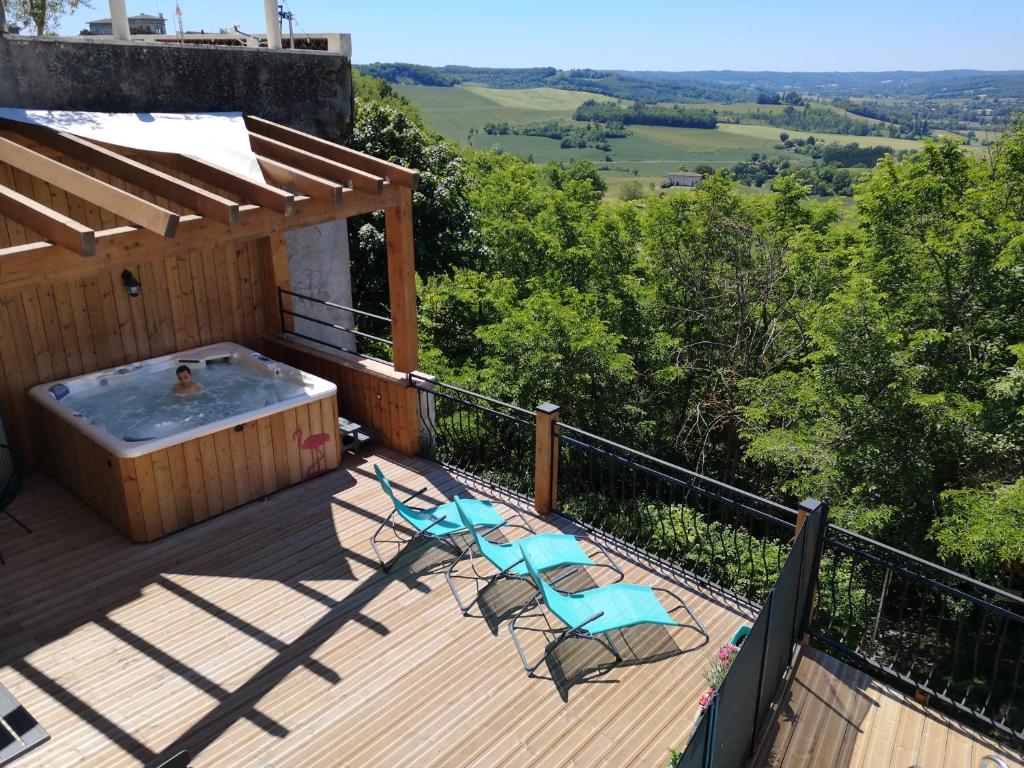 une terrasse avec deux chaises et un bain à remous dans l'établissement 4 place de la Rose, à Castelnau-de-Montmiral