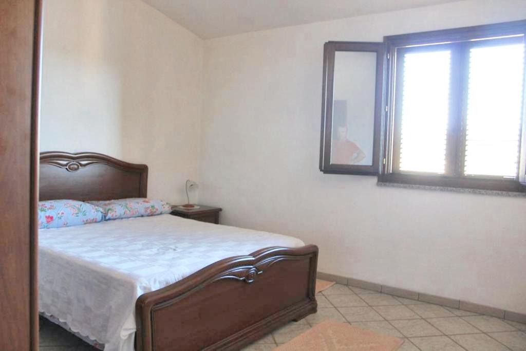 sypialnia z łóżkiem, lustrem i oknem w obiekcie Charming apartment in Nughedu Santa Vittoria - 90 m² with fireplace w mieście Nughedu Santa Vittoria
