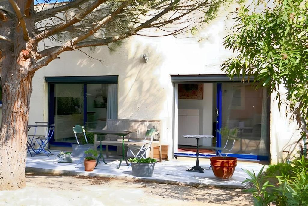 un patio d'une maison avec une table et des chaises dans l'établissement Appartement charmant à Saint-Quentin-la-Poterie, 40 m², jardin., à Saint-Quentin-la-Poterie