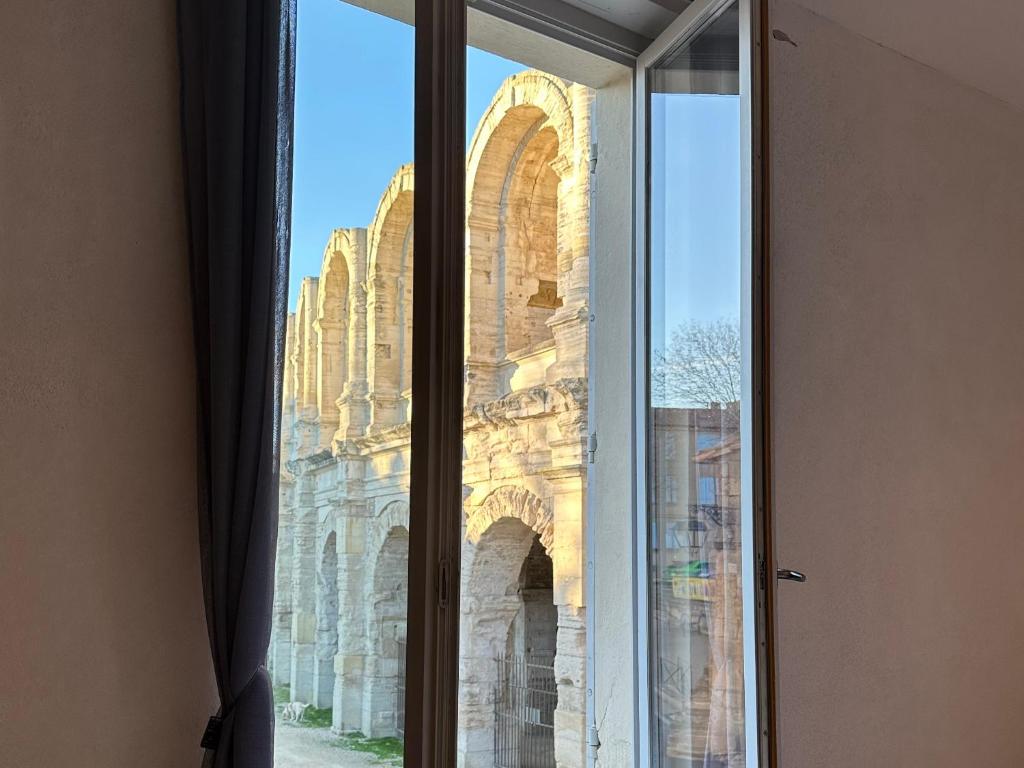 une fenêtre ouverte avec vue sur un bâtiment dans l'établissement Le clos la Major, à Arles