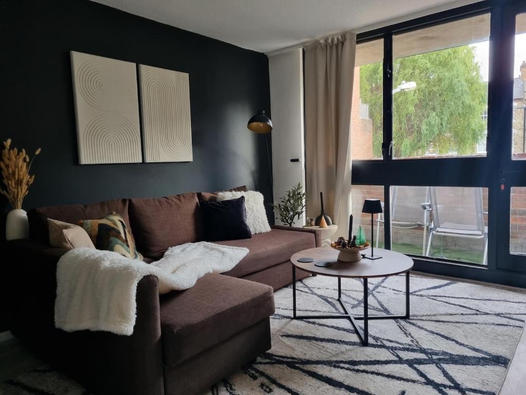 a living room with a couch and a table at Spacious and modern flat in Archway in London