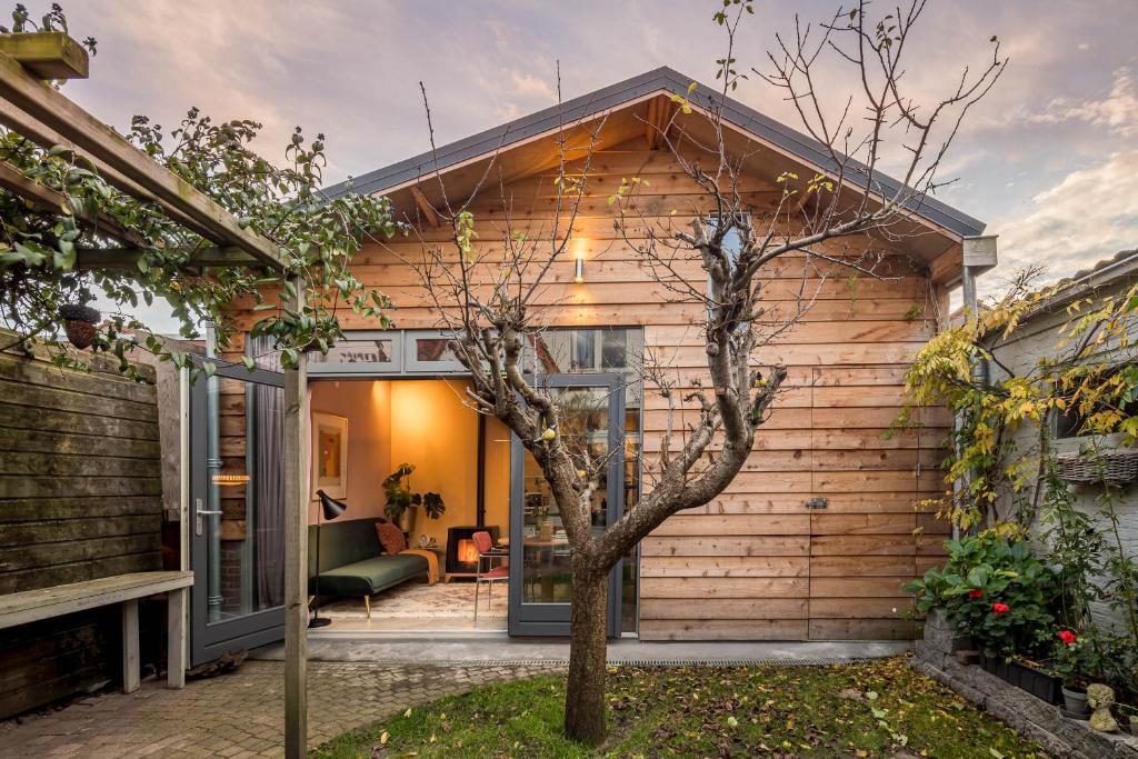 una casa de madera con un árbol delante en Deborah's Hiding Place, en Alkmaar