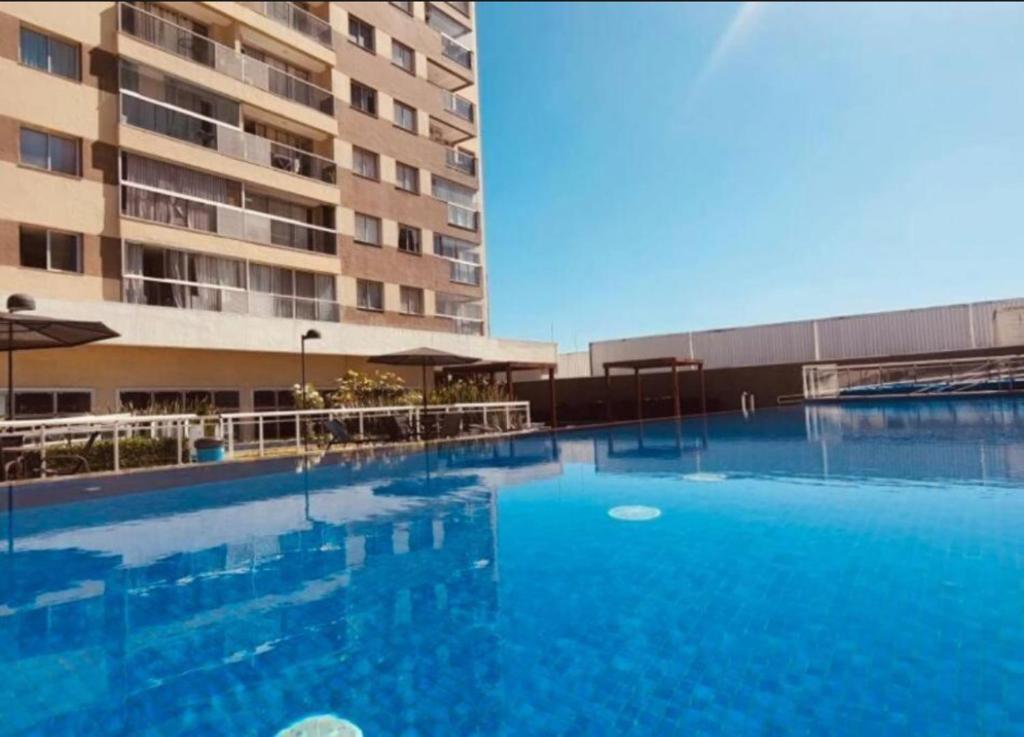 ein großes Schwimmbad vor einem Gebäude in der Unterkunft Apartamento charmoso e confortável no DF Century Plaza in Brasilia