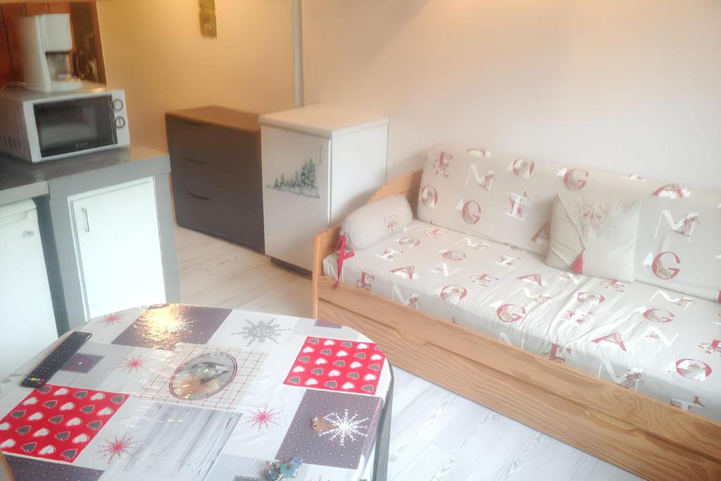 ラ・ブレスにあるAppartement cosy à La Bresse - 16 m² - Parking disponibleのソファとテーブルのあるリビングルーム