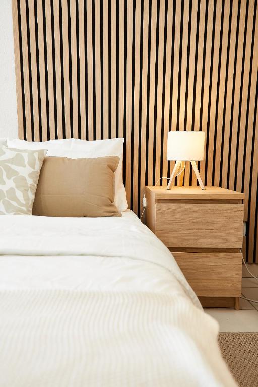 une chambre avec un lit et une table avec une lampe dans l'établissement Le Chic Urbain - Hôpitaux Facultés - Chateau d'Ô - Free Parking, à Montpellier