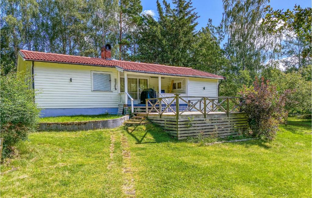 a small white house with a porch in a yard at Amazing Home In Herräng With Wifi in Herräng
