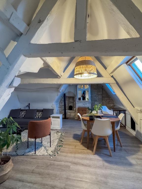 une pièce avec une table, des chaises et un plafond dans l'établissement Luna, à Caen