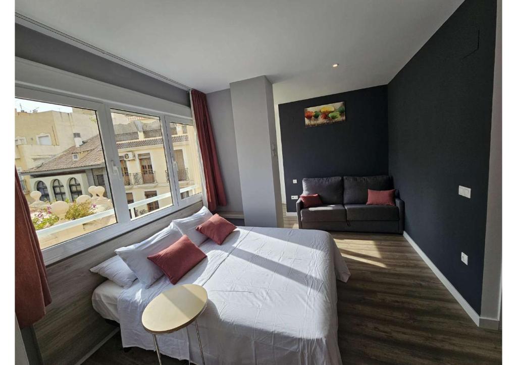 Un dormitorio con una cama grande y una ventana grande. en Apartamentos Turísticos KENZAMIN, en Alicante