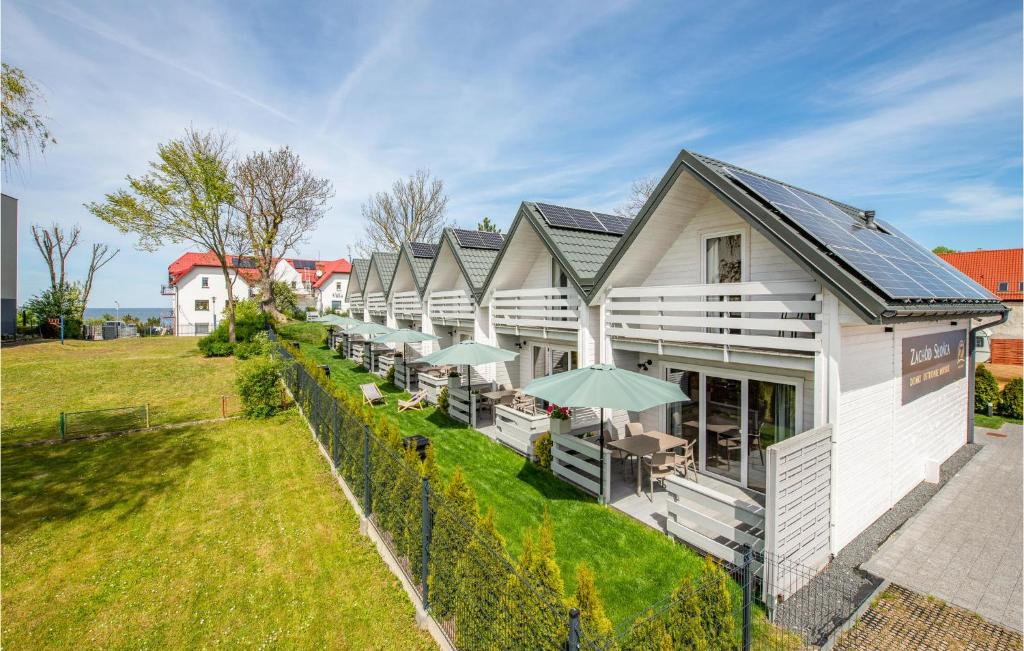 una fila di edifici bianchi con tavoli e ombrelloni di 2 Bedroom Cozy Home In Ustronie Morskie a Ustronie Morskie