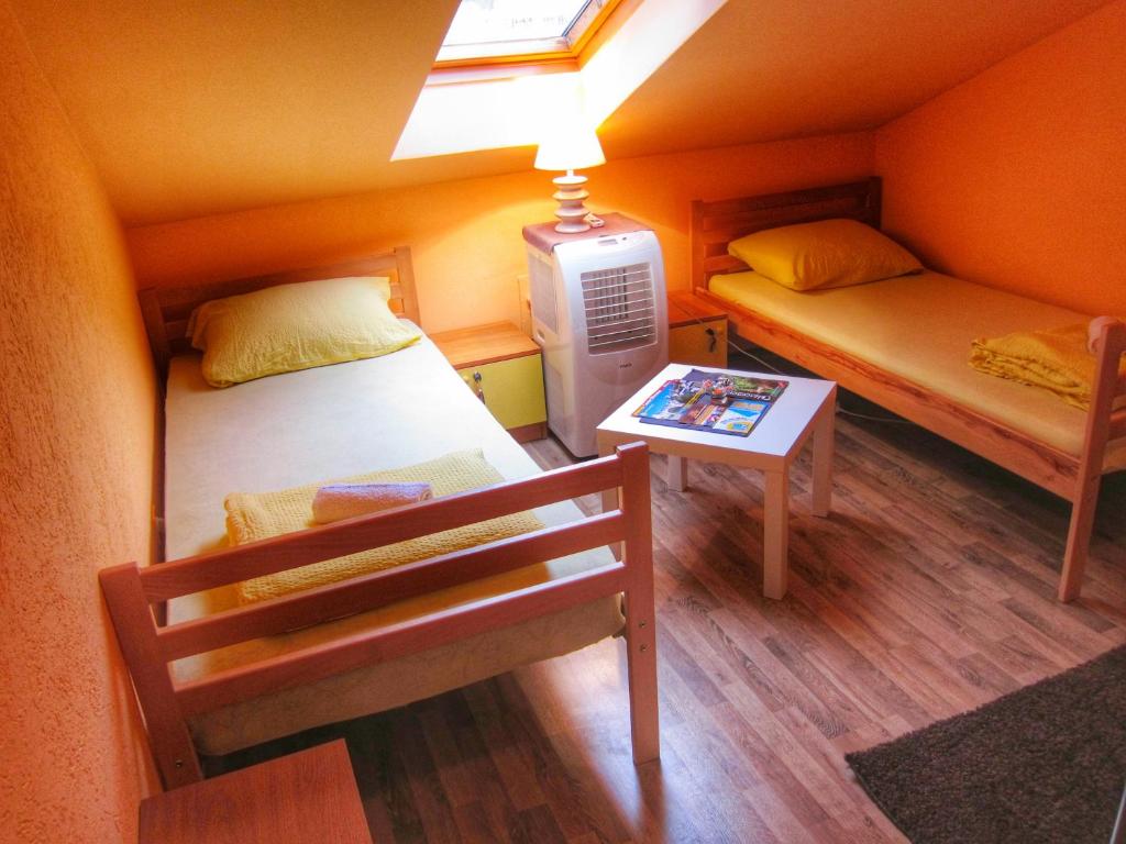 Kleines Zimmer mit 2 Betten und einem Tisch in der Unterkunft Hostel Taso's House in Mostar