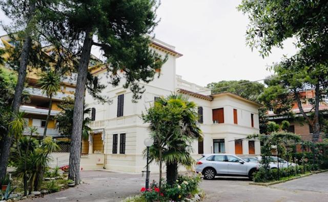 a car parked in front of a white building at Hotel VILLA PINA in Senigallia