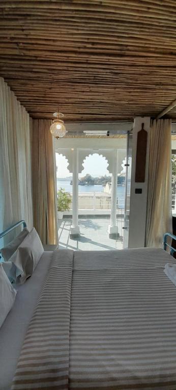Un dormitorio con una cama con vista al mar. en Paddy's Loft The Lake view hostel, en Udaipur