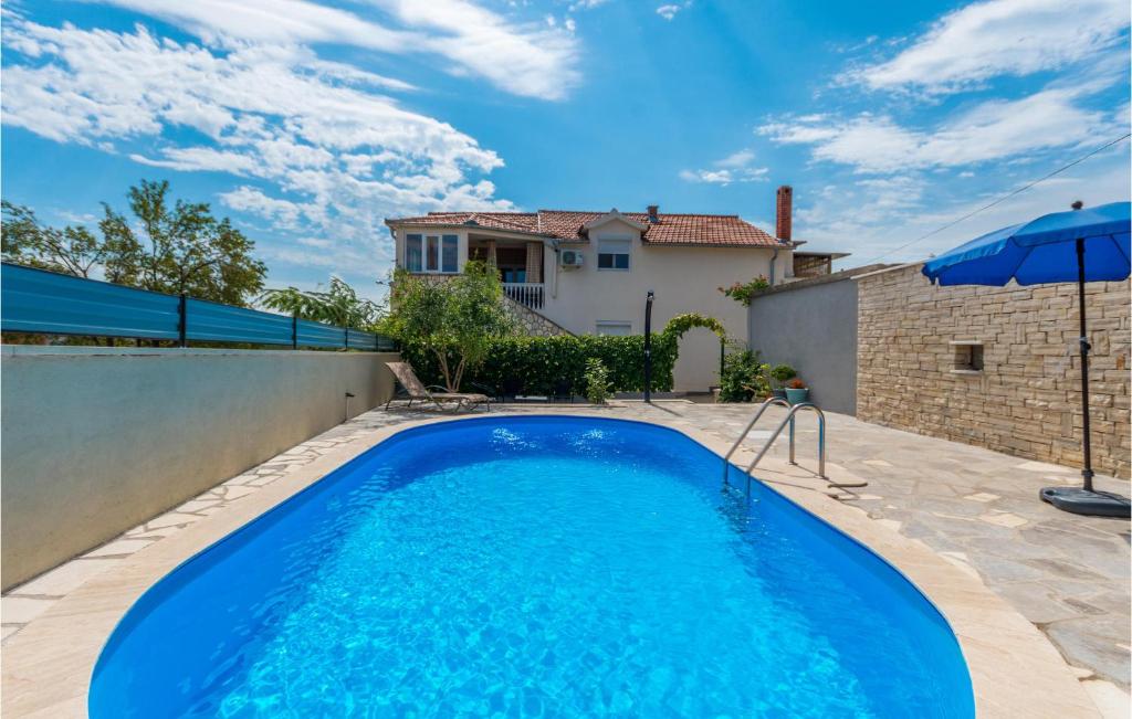 a swimming pool in the backyard of a house at 3 Bedroom Amazing Apartment In Banjevci in Banjevci