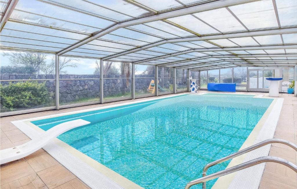 an indoor swimming pool with an open ceiling at Cozy Home In Calatabiano With Sauna in Calatabiano