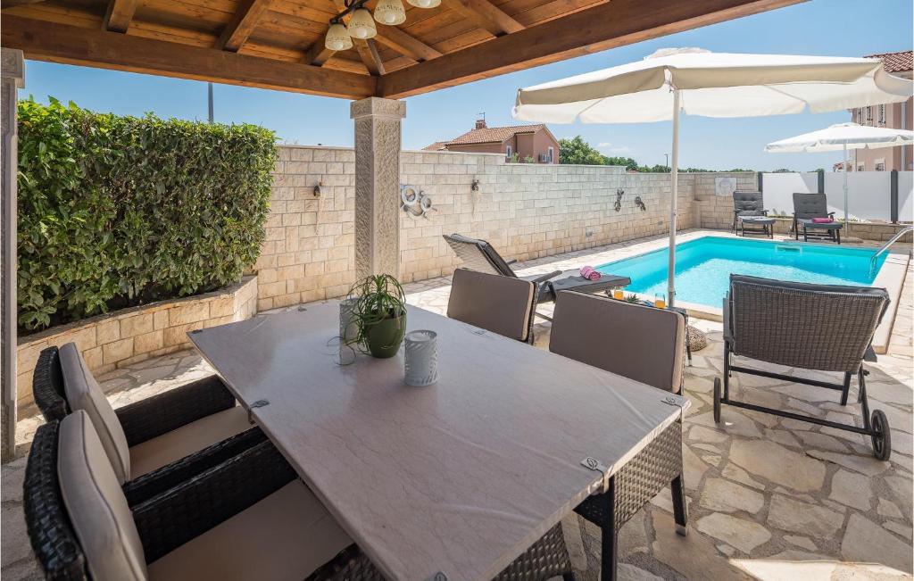 stół i krzesła na patio z basenem w obiekcie Holiday Home Kastelir 50 With Outdoor Swimmingpool w mieście Kaštelir