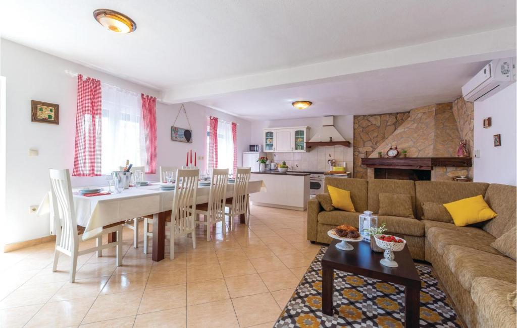 a living room and kitchen with a table and a couch at Three-Bedroom Holiday Home In Katuni in Katuni