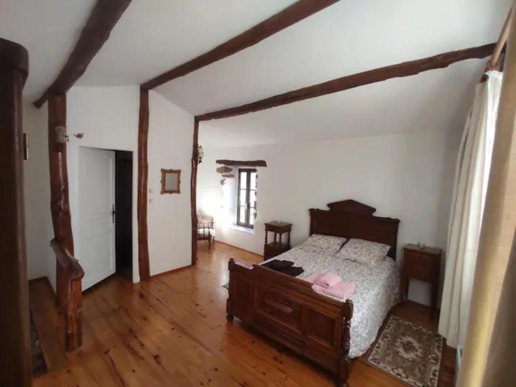 une chambre avec un lit et un parquet dans l'établissement Gîte La Fount, à Montoulieu