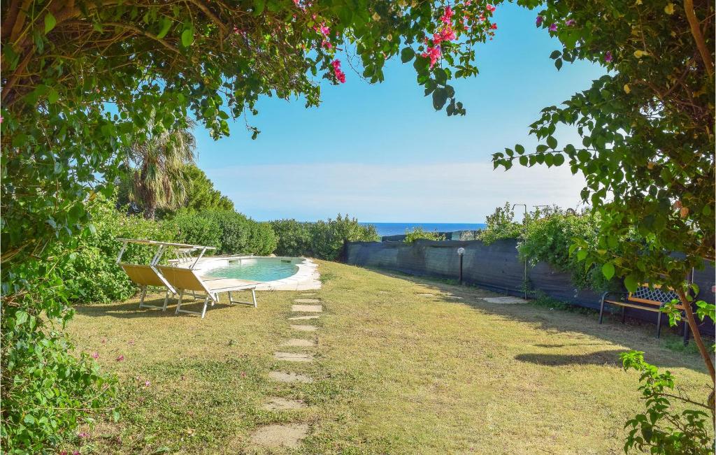 a yard with a swimming pool and two chairs at Vespucci in Costa Rei