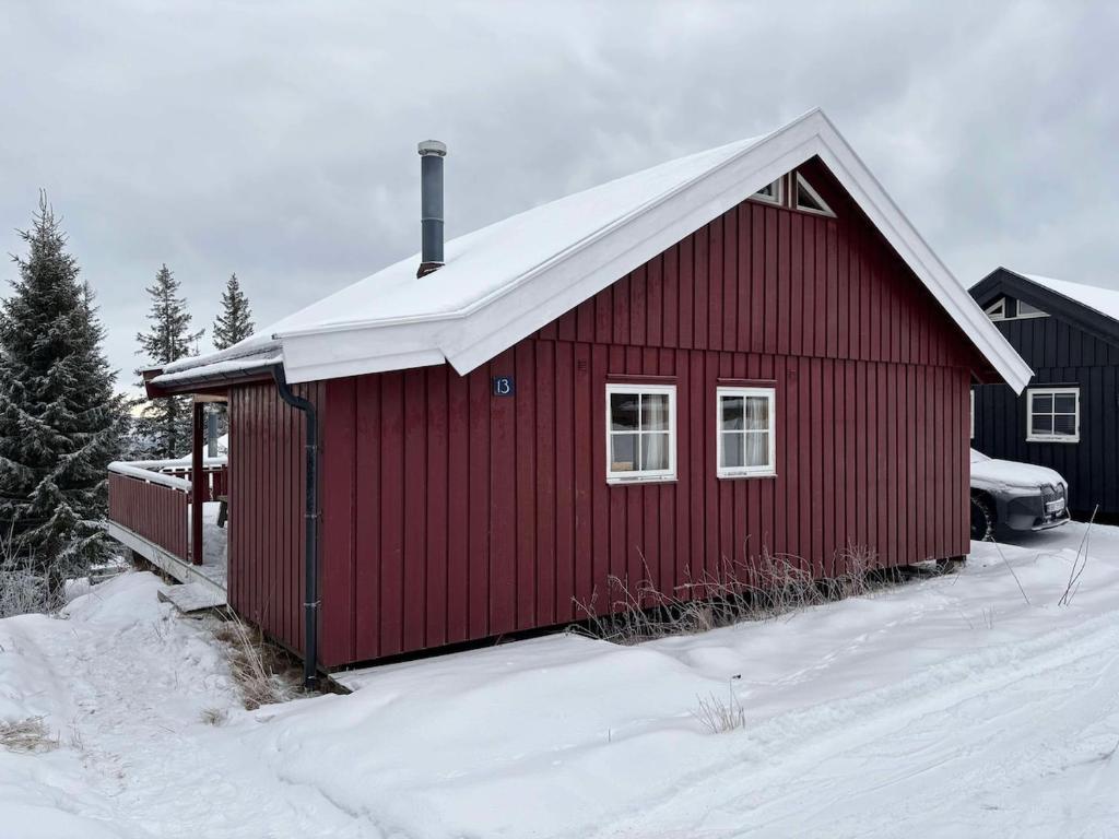 a red building with snow on top of it at Convenient ski in-out on Norefjell in the alpine village in Surteberg