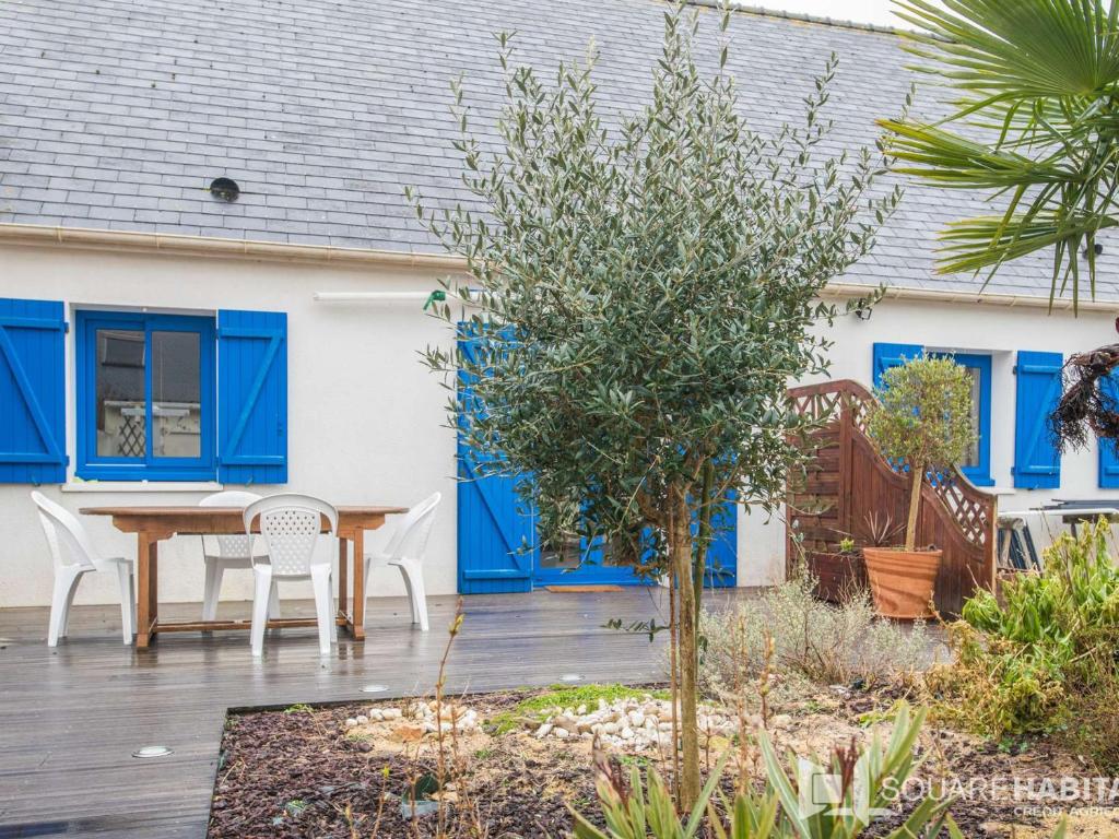 un patio avec une table et des chaises devant une maison dans l'établissement Villa calme, terrasses, animaux acceptés, parking, WiFi - FR-1-479-202, à Étel