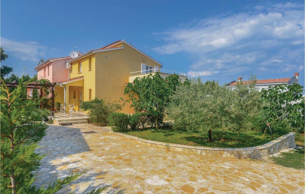 une villa avec un jardin et une maison dans l'établissement Two-Bedroom Holiday Home In Liznjan, à Ližnjan