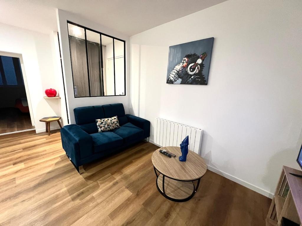 un salon avec un canapé bleu et une table dans l'établissement Colours Home Plein coeur de Poitiers, à Poitiers