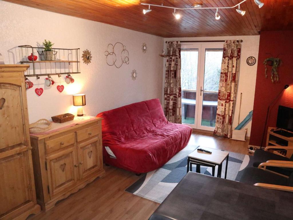 un salon avec un canapé rouge et une table dans l'établissement Bel appart 2P, rénové, balcon expo sud, Les Orres - FR-1-322-199, aux Orres