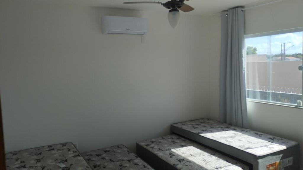 a room with two beds and a window at Casa do Bosque - Guriri-ES - 10 pessoas in São Mateus