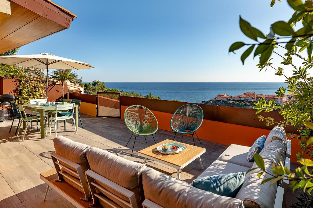 d'une terrasse avec un canapé et des chaises donnant sur l'océan. dans l'établissement La Terrasse Bleue, à Collioure