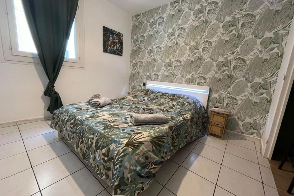 a bedroom with a bed with towels on it at Spacieux appartement proche des halles Wifi in Narbonne