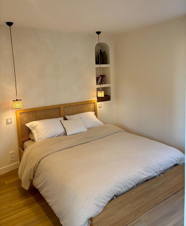 une chambre avec un grand lit avec deux oreillers dans l'établissement Sea view apartment with balcony, à Saint-Malo