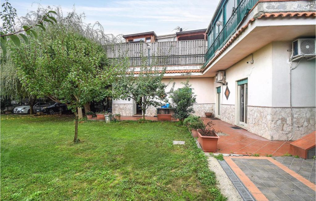 une maison avec une cour et un arbre en face de celle-ci dans l'établissement 2 Bedroom Cozy Apartment In Napoli, à Naples