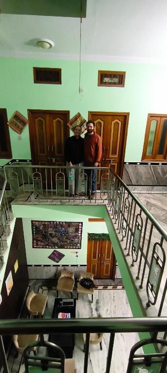 two men standing on a staircase in a building at Rose Merry Guesthouse in Bikaner