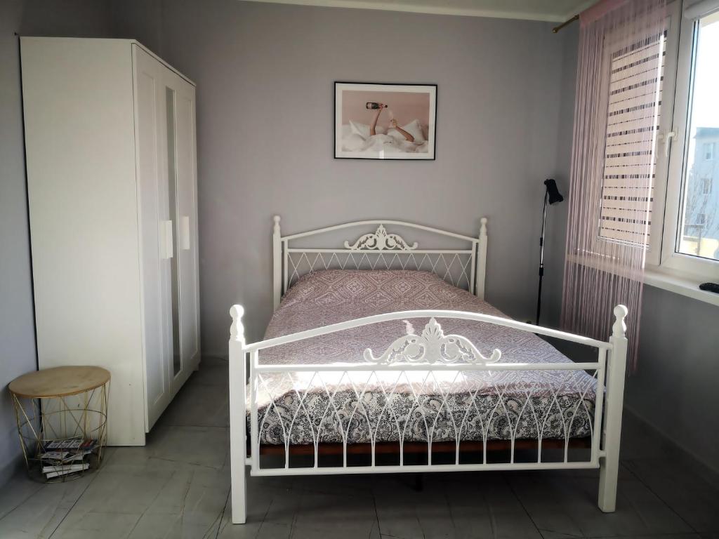 a white bed in a room with a window at Różowe sny in Kłodzko