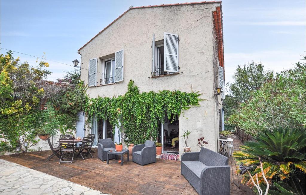 a house with a patio with chairs and a table at Awesome Apartment In Cagnes-Sur-Mer in Cagnes-sur-Mer