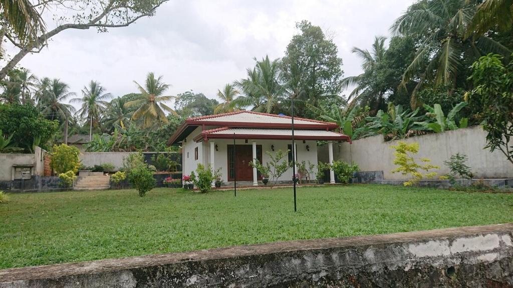 a small house with a green lawn in front of it at Paddy view villa near Bentota in Bentota