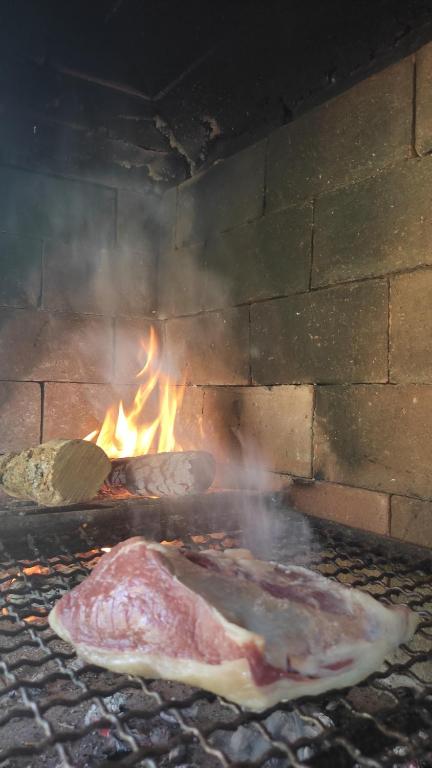 due pezzi di carne che cuociono in un forno di mattoni di La Celeste a La Granja