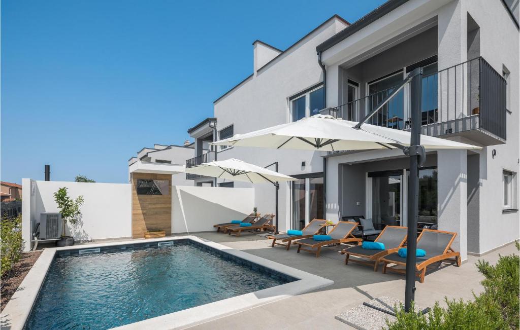 Bild eines Hauses mit Pool und Sonnenschirmen in der Unterkunft 4 Bedroom Stunning Home In Nova Vas in Nova Vas