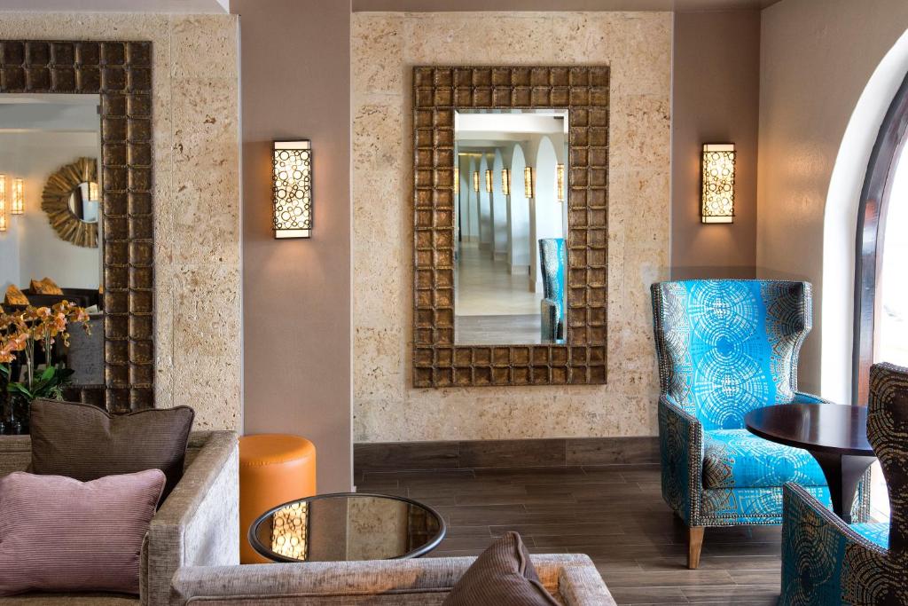a living room with a blue chair and a mirror at Oyster Bay Beach Resort in Dawn Beach