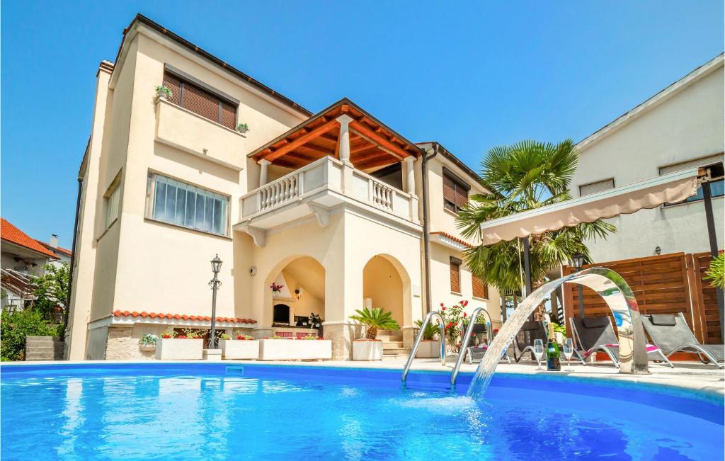 a swimming pool in front of a house at Cozy Apartment In Viskovo in Viskovo