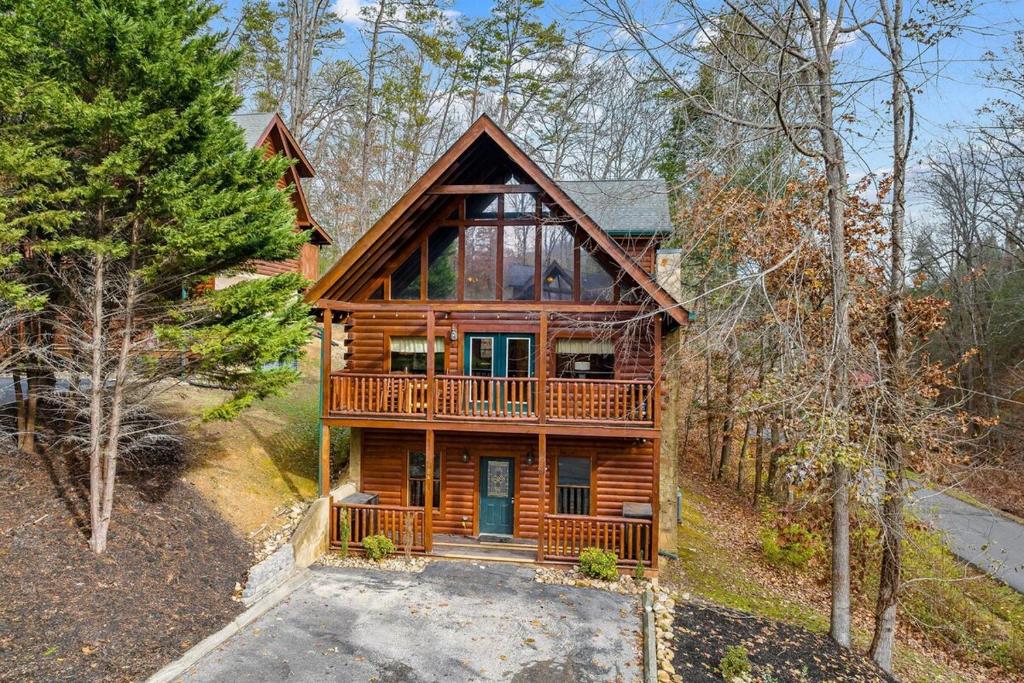 a log home with a porch and a deck at NewListing 1mile Parkway, GameRoom, HotTub, BBQ, Sleeps 14, 5 Bedroom with attached Bath, PET Friendly in Pigeon Forge