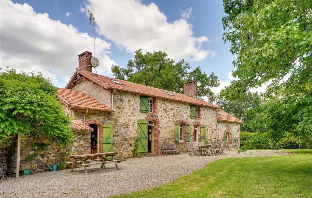 una casa in pietra con una panca da picnic di fronte di Beautiful Home In Nieul Le Dolent With Wifi a Nieul-le-Dolent