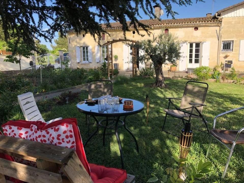- une table et des chaises dans la cour d'une maison dans l'établissement Charmante dépendance, à Izon